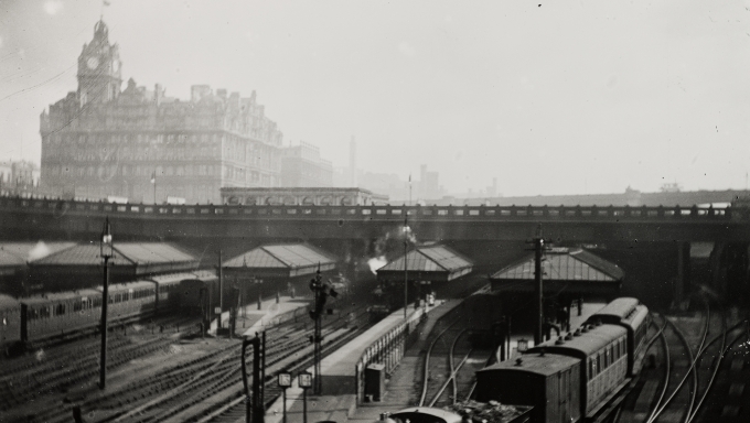 Black and white photograph of Waverley Station with the Balmoral Hotel and North Bridge in the background